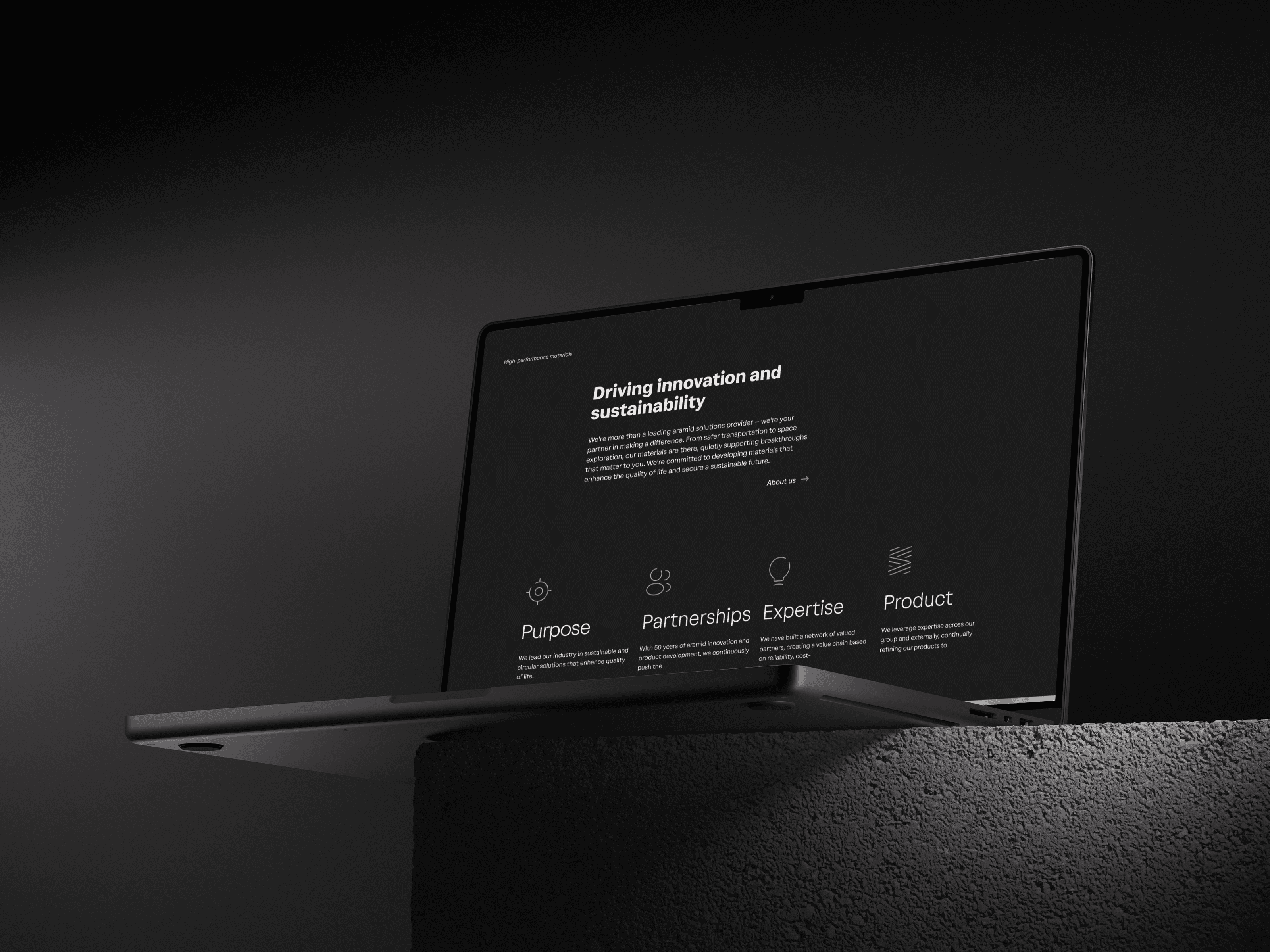 A laptop showing the dark Teijin Aramid homepage: "Driving innovation and sustainability" above four pillars - Purpose, Partnerships, Expertise, Product